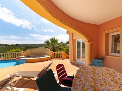 Terrasse couverte donnant sur la piscine et le jacuzzi. Mobilier d'extérieur et design architectural méditerranéen.