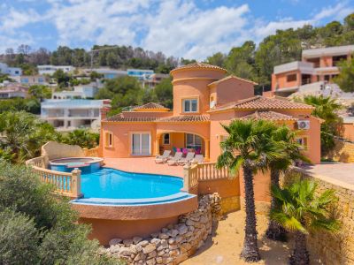 Vue aérienne de la villa avec piscine turquoise et jacuzzi intégré, entourée de palmiers et de jardins.