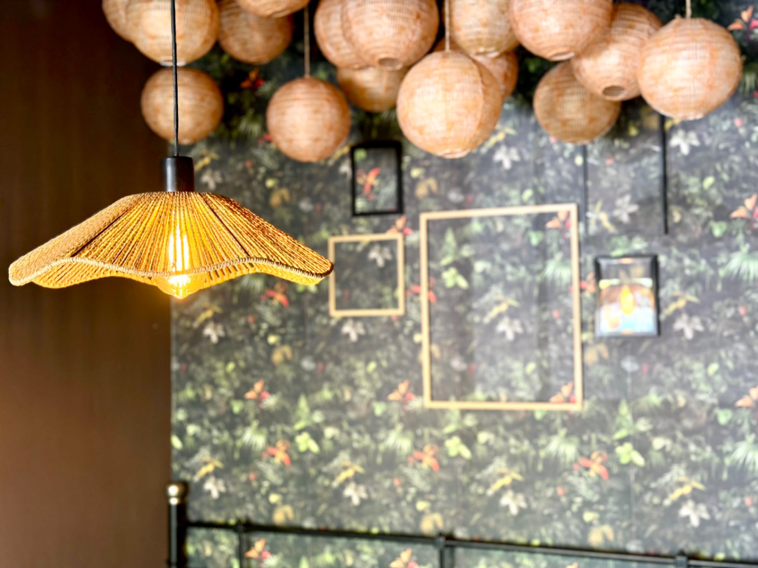 Gros plan d'une lampe en fibre et d'une décoration florale sur un mur de chambre.