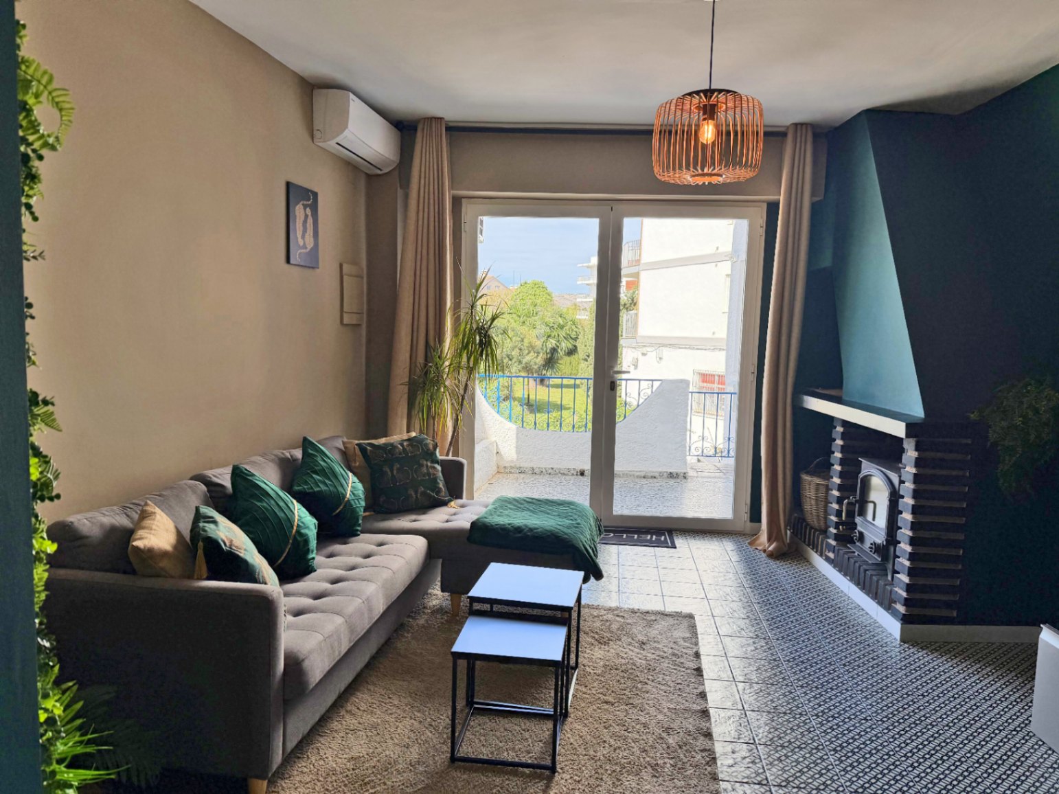 Salon lumineux avec cheminée et accès terrasse offrant des vues extérieures.