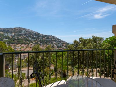 Balcon avec balustrade en fer forgé et mobilier, offrant des vues panoramiques sur la colline d'Altea Hills, ses résidences, sa végétation luxuriante et la mer Méditerranée.