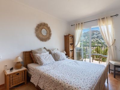 Chambre lumineuse avec lit et tête de lit en osier, accès direct à un balcon privé. Elle dispose de carrelage et de vues panoramiques sur les collines d'Altea Hills.