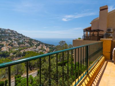 Grande terrasse extérieure avec balustrade en fer forgé vert, sol en céramique et vues panoramiques sur Altea Hills et la mer Méditerranée azur.