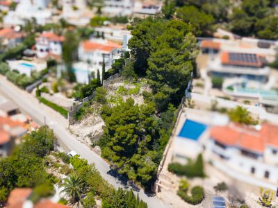Vue aérienne du quartier résidentiel de Montemar, avec villas, piscines privées, végétation méditerranéenne dense et routes sinueuses.