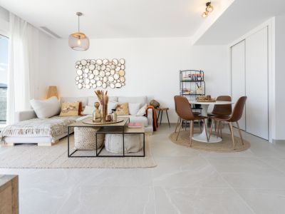 Grand salon-salle à manger ouvert avec canapé sectionnel clair, miroir mural circulaire distinctif et table à manger ronde avec chaises modernes. Grandes fenêtres apportent lumière naturelle et vue sur la montagne.