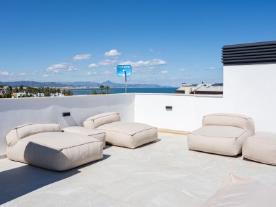 Vaste terrasse sur le toit avec des sièges modulaires sur des carreaux clairs, offrant des vues panoramiques sur la mer Méditerranée et la côte de Dénia.