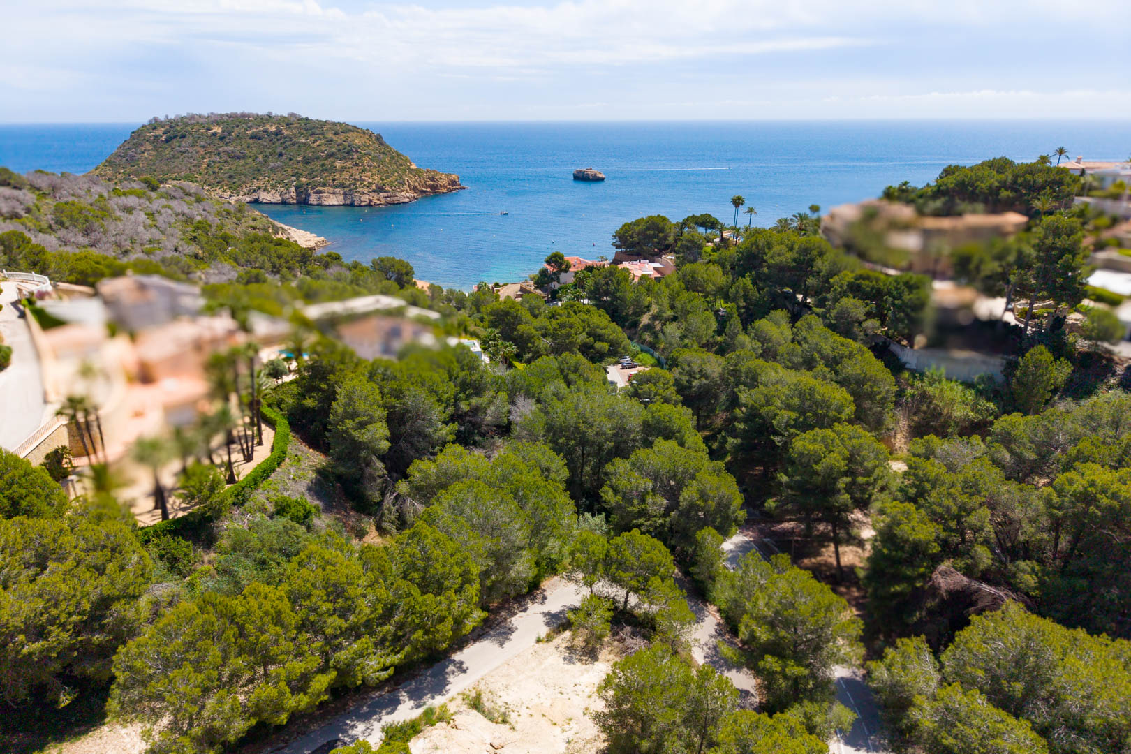Vue aérienne de la parcelle boisée avec accès routier, surplombant la mer et le promontoire à Jávea.