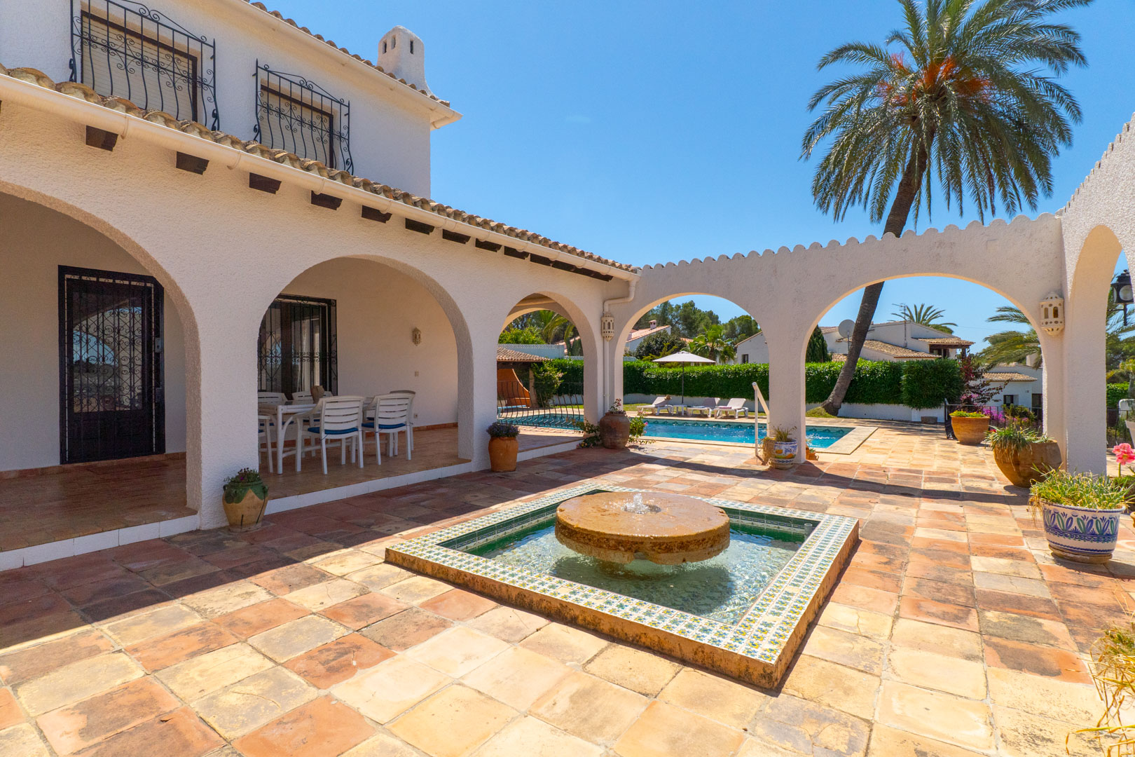 Patio avec fontaine en pierre et accès piscine, dans villa à Moraira.