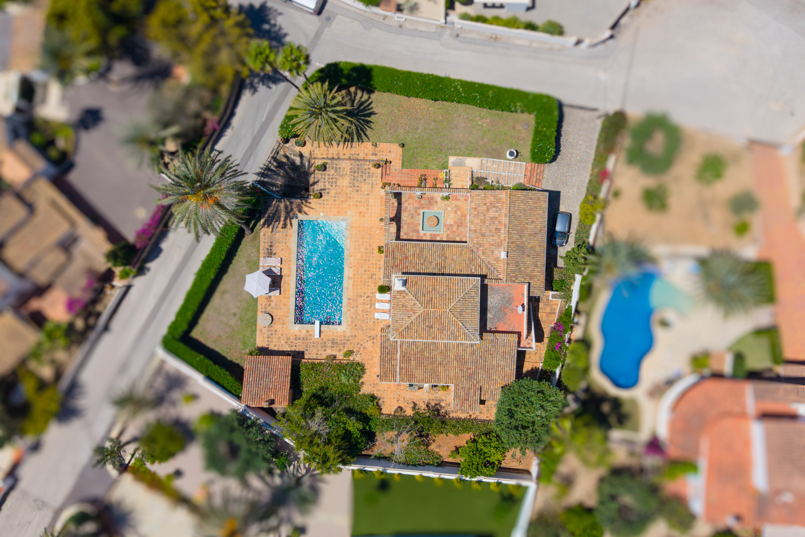 Vue aérienne de la villa avec piscine rectangulaire et toit en tuiles rouges.