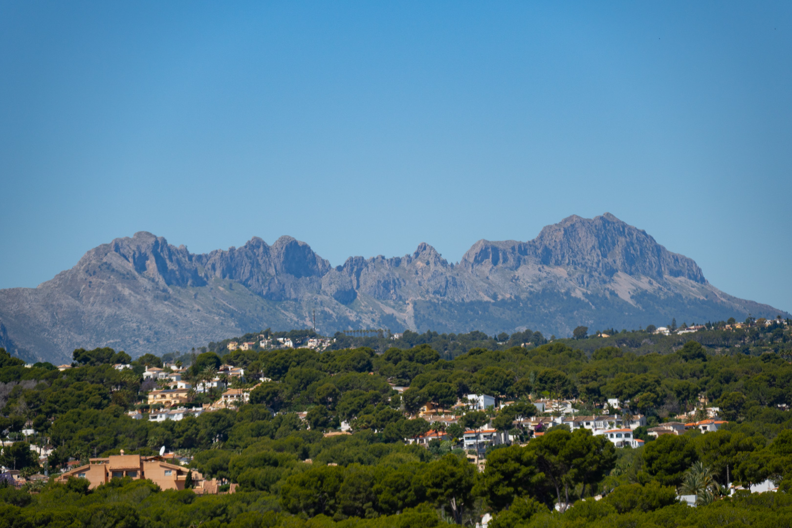 Vues panoramiques sur la Sierra de Bernia depuis la villa, entourée de verdure et d'autres résidences.