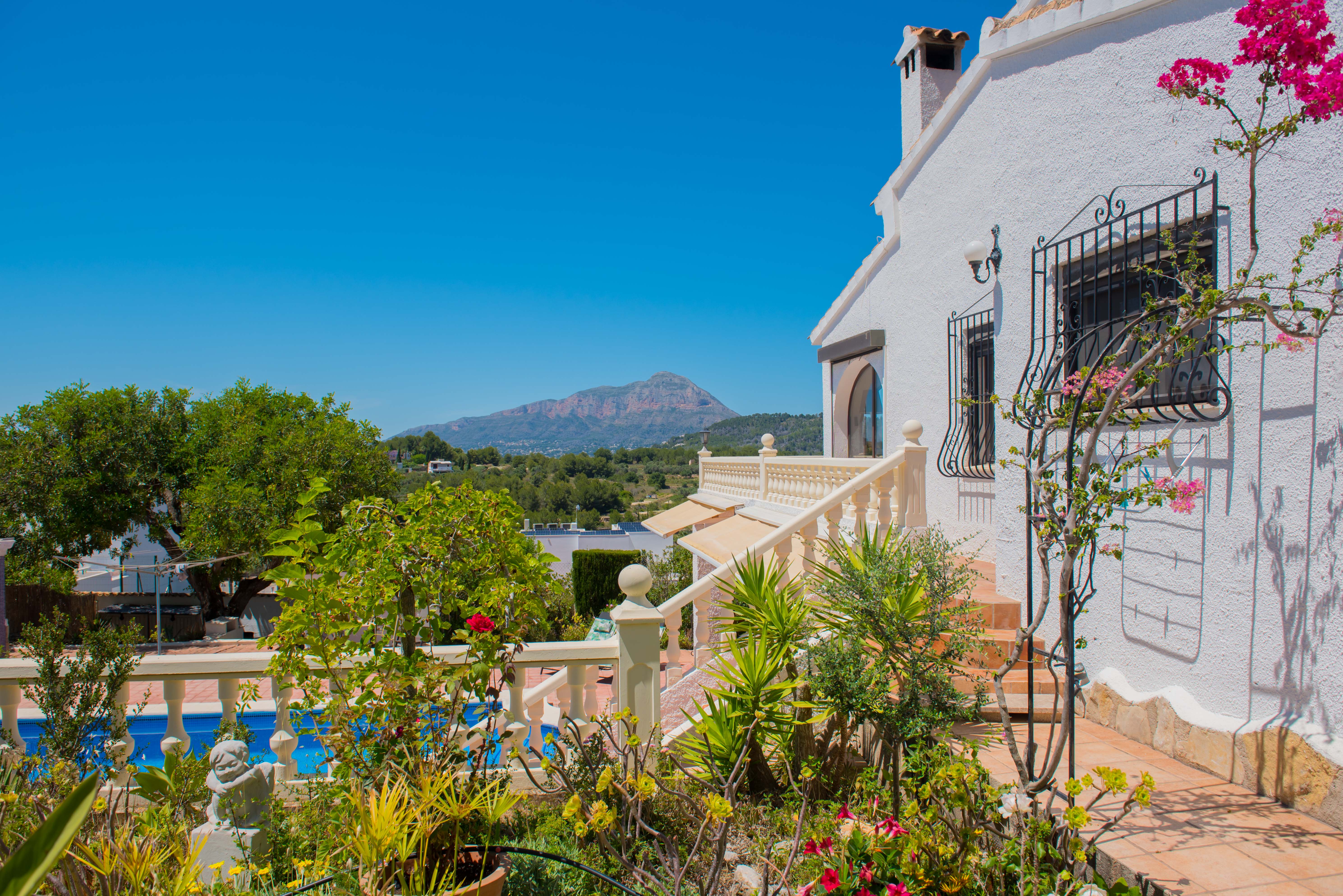 Jardin méditerranéen avec piscine et vue sur la montagne depuis la terrasse.