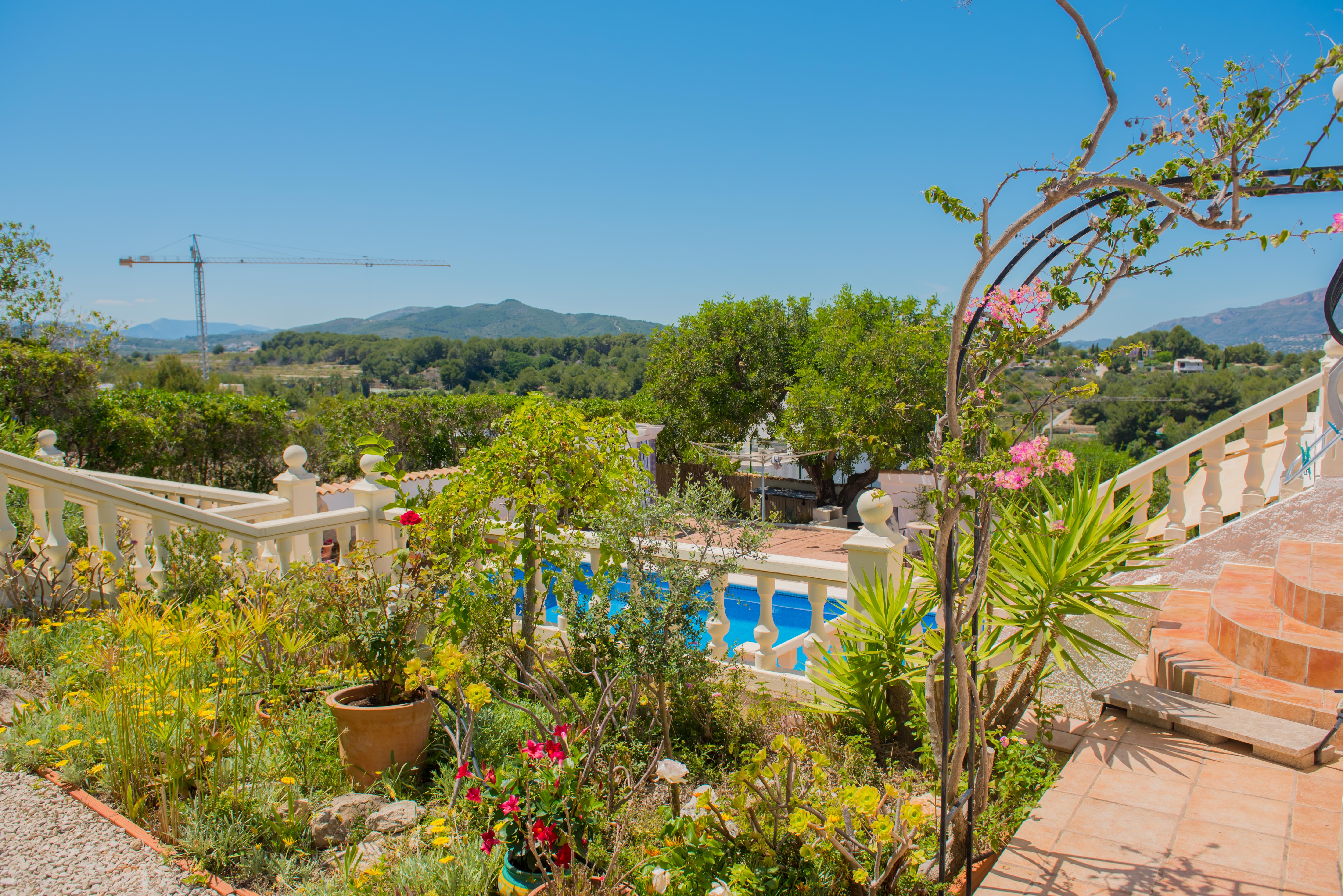 Jardin méditerranéen avec vue sur la piscine et balustrade en calcaire.