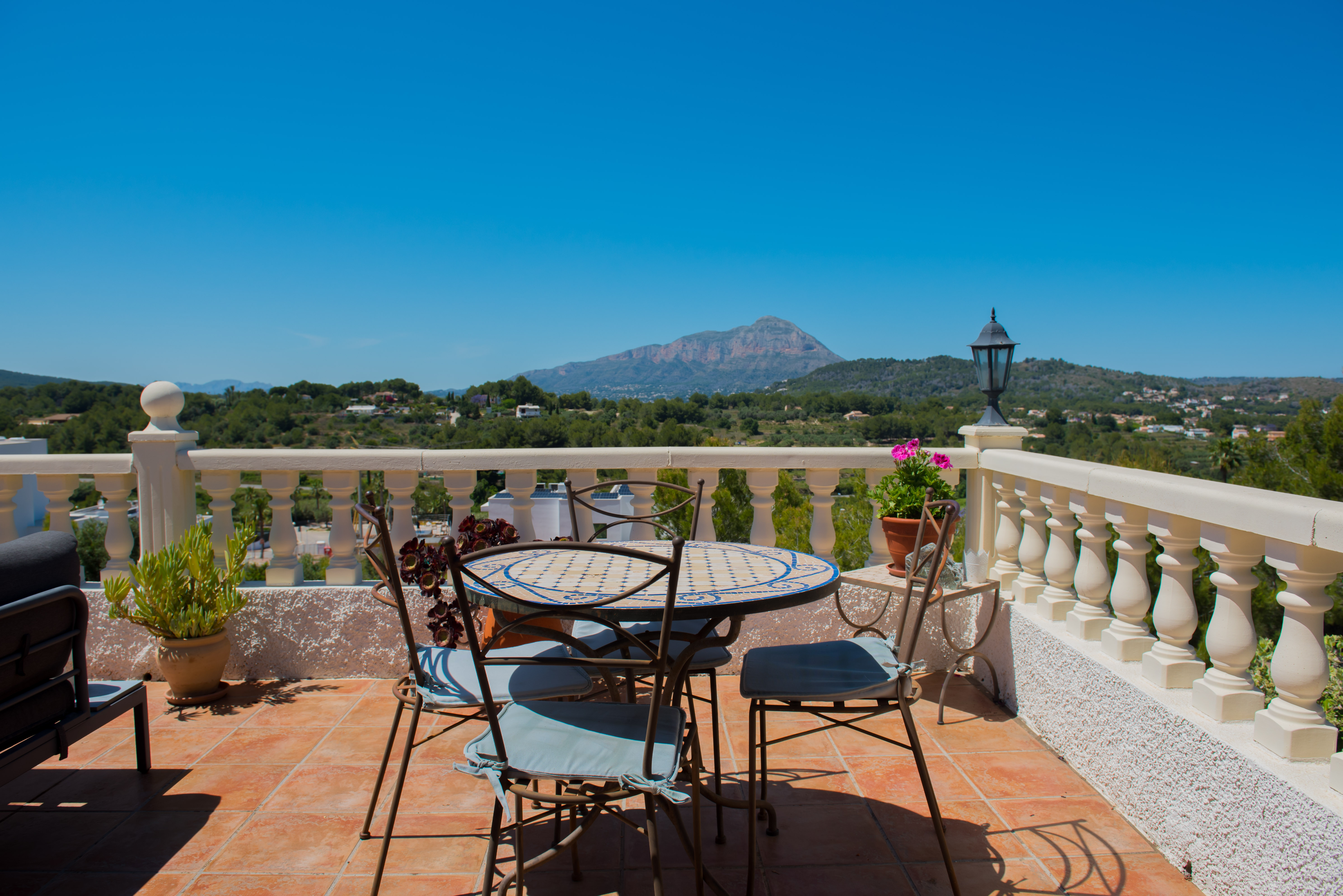 Terrasse avec table en mosaïque et vue sur la montagne.