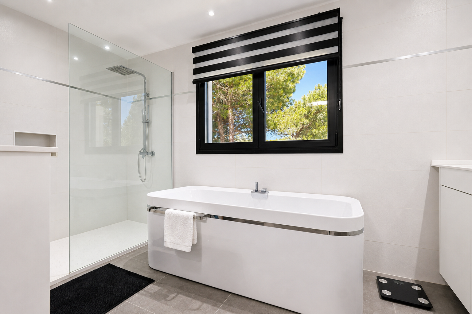 Élégante salle de bain avec baignoire îlot, douche en verre et fenêtre donnant sur l'extérieur.