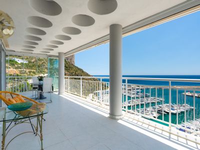 Vaste terrasse couverte avec carrelage clair, plafond à motifs circulaires et vues panoramiques sur le port de Calpe, la mer Méditerranée et le Peñón de Ifach.