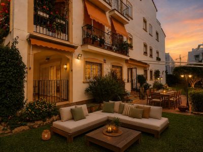 Jardin privé accueillant avec salon extérieur moderne et salle à manger sur terrasse carrelée sous pergola, éclairé par un coucher de soleil.