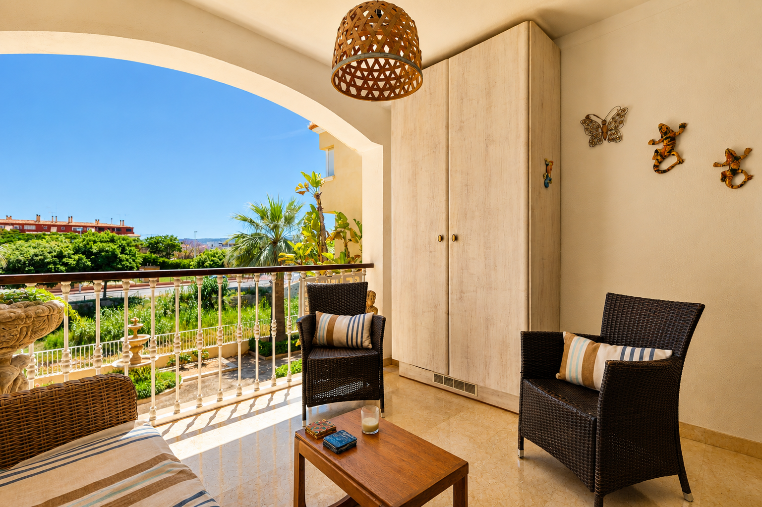Vaste terrasse privée avec sol en marbre, mobilier en rotin et table en bois. Comprend un placard intégré et offre des vues sur la verdure et le ciel clair.