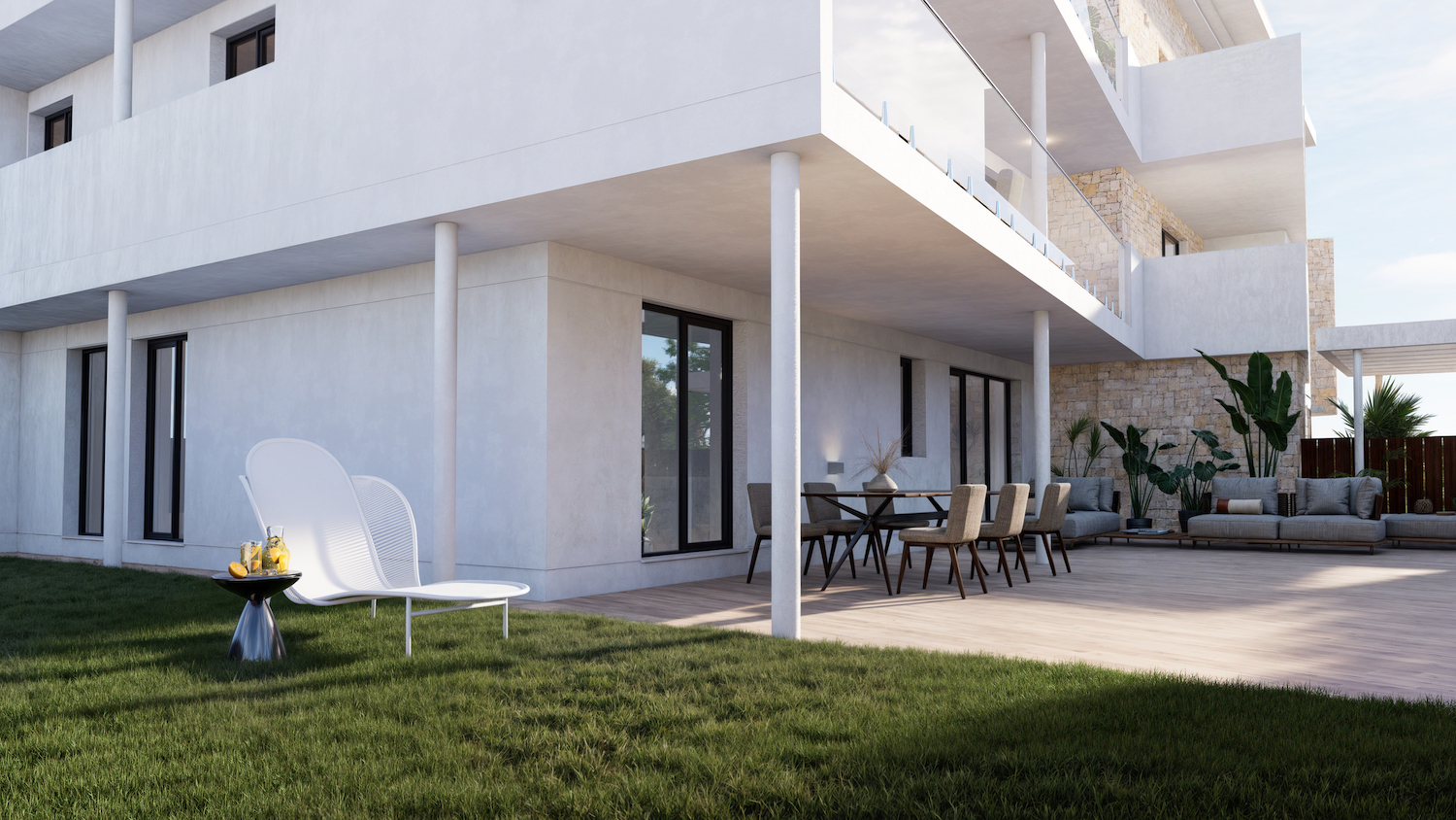 Vaste terrasse au rez-de-chaussée avec un plancher en bois clair, un ensemble repas et un coin salon extérieur, ouvrant sur une pelouse entretenue avec une chaise longue design.