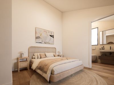 Chambre principale sereine avec tête de lit en rotin, tables de chevet en bois clair et tapis rond en fibres naturelles. Aperçu d'une salle de bain moderne avec meuble vasque suspendu.