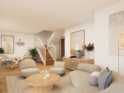 Espace de vie et salle à manger ouverts avec canapé incurvé, deux fauteuils et table basse ronde en bois sur un tapis tissé. Un escalier en bois moderne relie les étages.