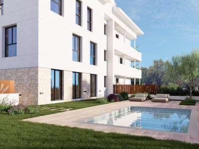 Immeuble d'appartements moderne avec façade blanche épurée et soubassement en pierre. Il offre un jardin privé avec piscine rectangulaire, revêtement aspect bois clair et deux chaises longues contemporaines.