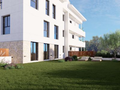 L'immeuble blanc moderne présente un soubassement en pierre et de grandes baies vitrées s'ouvrant sur une vaste pelouse. Aménagement paysager méditerranéen avec chaises longues.