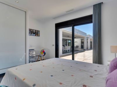 Chambre lumineuse avec accès direct à la terrasse, dotée d'une armoire intégrée à portes coulissantes et d'un coin bureau pratique.