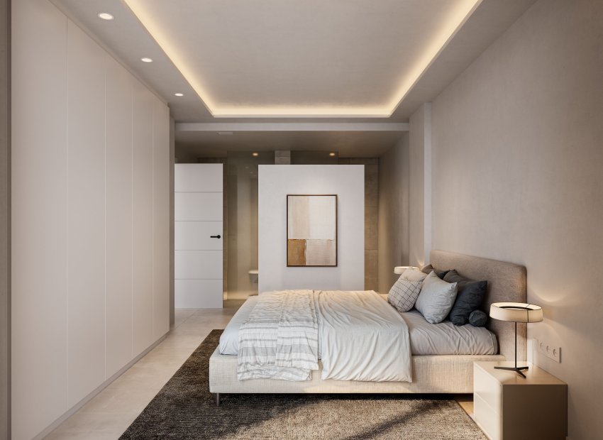 Chambre principale contemporaine aux tons neutres, intégrant des armoires du sol au plafond et un faux plafond avec éclairage LED ambiant. Une cloison partielle sépare l'espace nuit de la salle de bain privative.