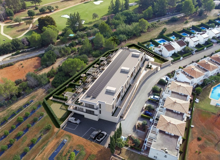 Vue aérienne d'un bâtiment moderne avec toit solaire et une vaste terrasse paysagée comprenant des pergolas, des sièges extérieurs et un putting green, adossé à un parcours de golf.
