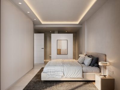 Chambre principale contemporaine aux tons neutres, intégrant des armoires du sol au plafond et un faux plafond avec éclairage LED ambiant. Une cloison partielle sépare l'espace nuit de la salle de bain privative.