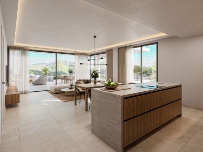 Espace de vie ouvert moderne avec îlot de cuisine en pierre et bois, salle à manger adjacente et salon lumineux. De grandes baies vitrées s'ouvrent sur une terrasse privée avec vue sur le paysage verdoyant.