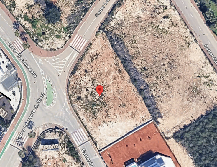 Vue aérienne d'une parcelle urbaine non bâtie, marquée d'une épingle rouge, située à côté d'un carrefour avec un rond-point et des voies urbanisées. Vue aérienne d'une parcelle urbaine non bâtie, marquée d'une épingle rouge, située à côté d'un carrefour avec un rond-point et des voies urbanisées.