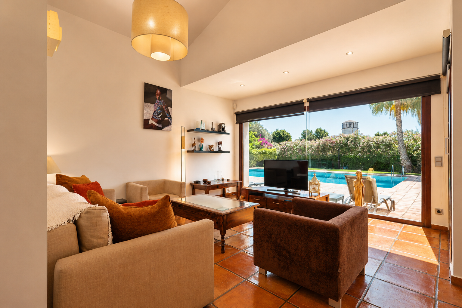 Vaste salon avec carrelage en terre cuite et accès direct à la piscine. La pièce bénéficie d'une lumière naturelle abondante, de sièges confortables et d'une vue sur le jardin et une tour lointaine. Vaste salon avec carrelage en terre cuite et accès direct à la piscine. La pièce bénéficie d'une lumière naturelle abondante, de sièges confortables et d'une vue sur le jardin et une tour lointaine.