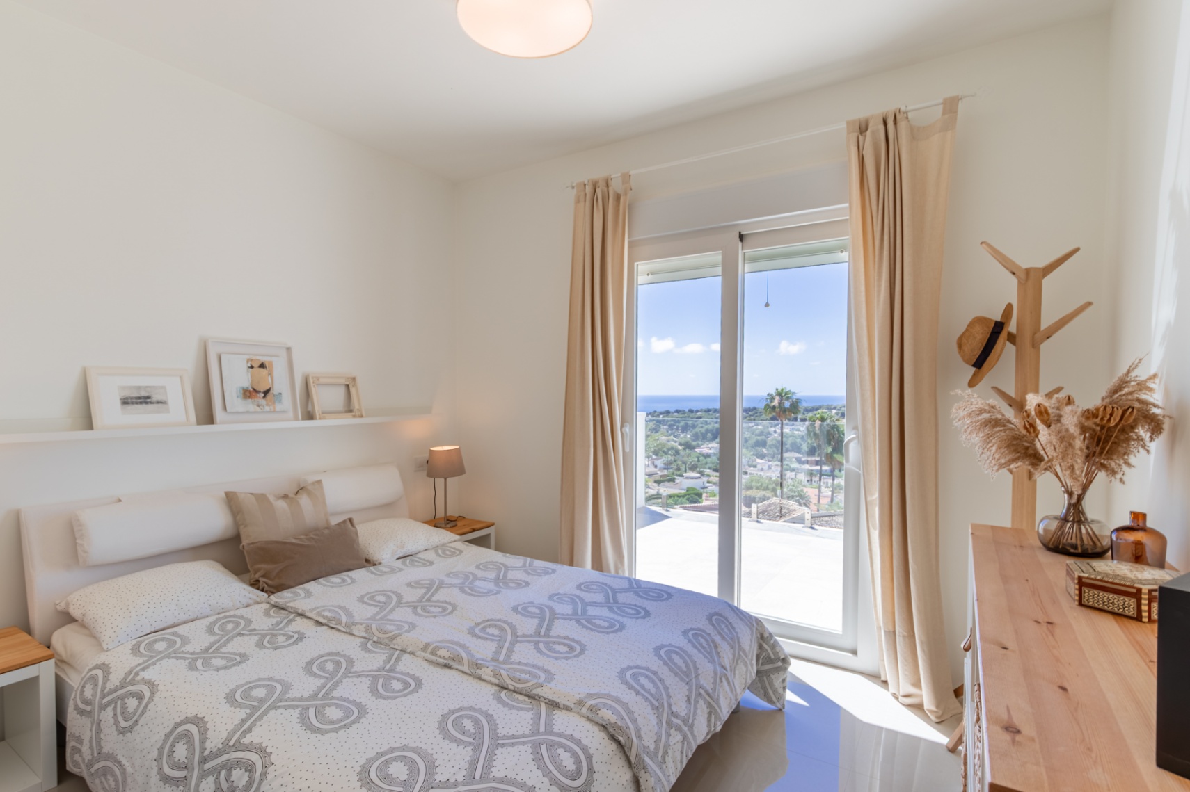 Chambre lumineuse à l'étage avec accès terrasse, offrant une vue panoramique sur la mer Méditerranée. Meubles en bois clair et carrelage au sol. Chambre lumineuse à l'étage avec accès terrasse, offrant une vue panoramique sur la mer Méditerranée. Meubles en bois clair et carrelage au sol.