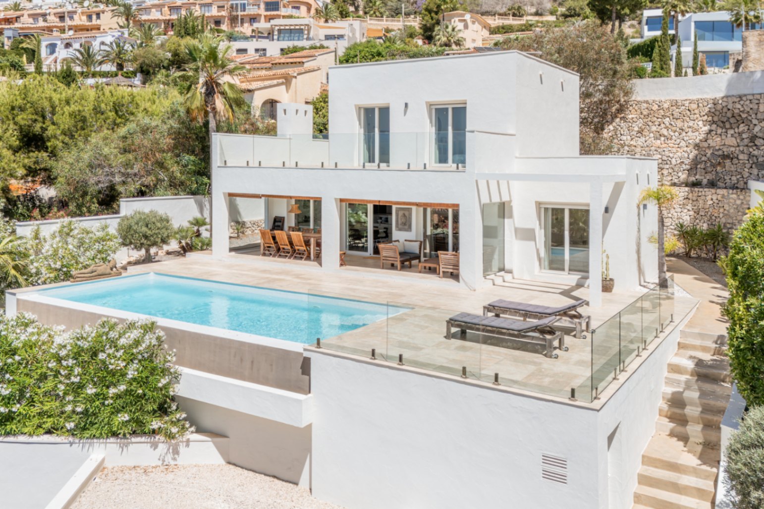 Villa moderne sur deux niveaux avec piscine à débordement et vastes terrasses carrelées. Comprend un espace repas extérieur couvert et un solarium. Villa moderne sur deux niveaux avec piscine à débordement et vastes terrasses carrelées. Comprend un espace repas extérieur couvert et un solarium.