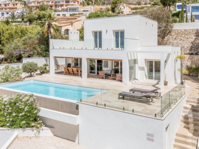 Villa moderne sur deux niveaux avec piscine à débordement et vastes terrasses carrelées. Comprend un espace repas extérieur couvert et un solarium.