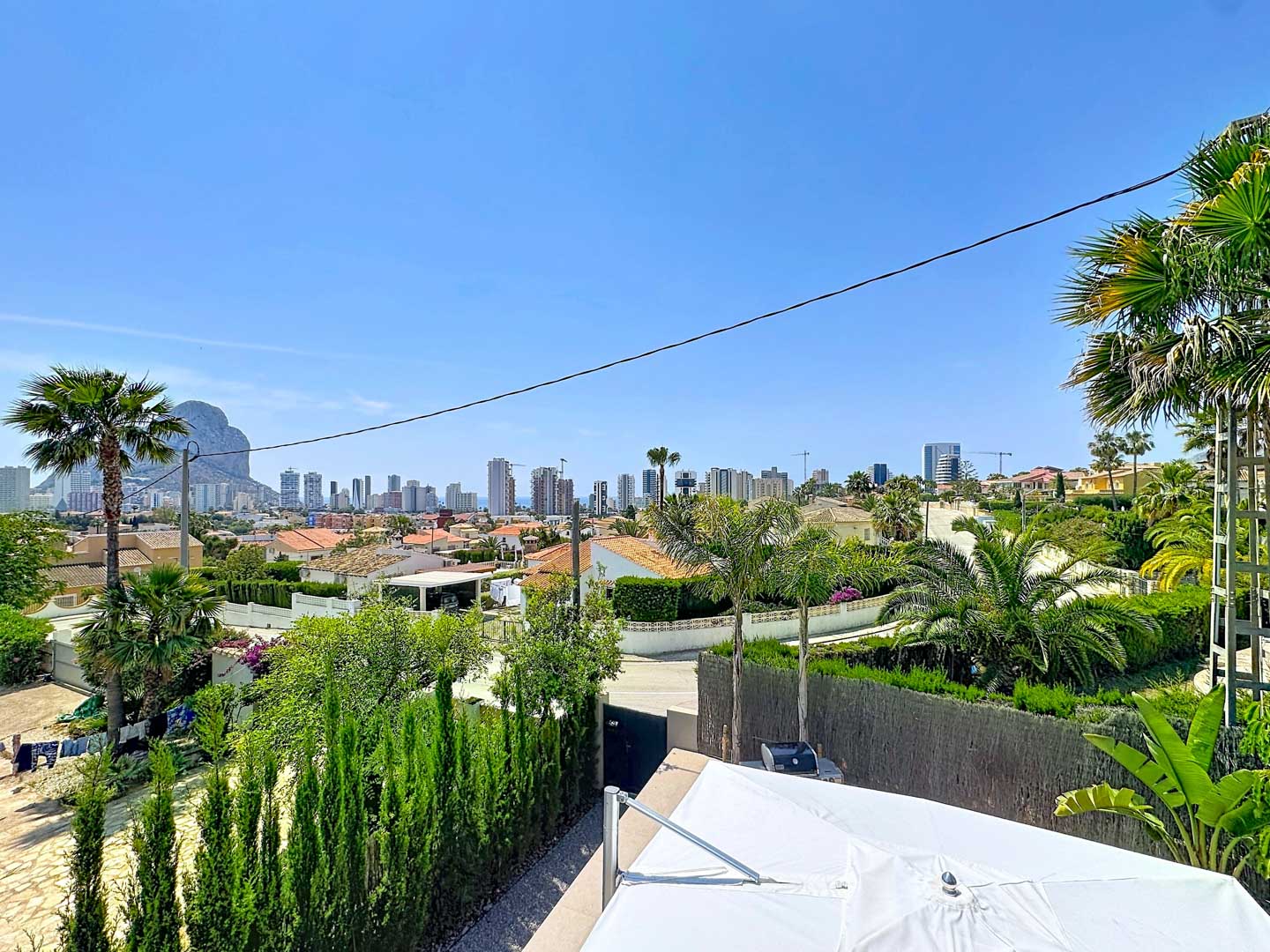Vues panoramiques depuis la propriété, révélant la ligne d'horizon de Calpe, le Peñón de Ifach emblématique et une végétation méditerranéenne luxuriante.
