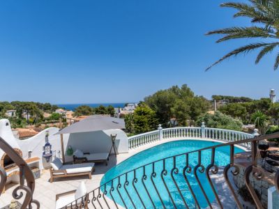 Piscine incurvée avec terrasse carrelée, barbecue extérieur traditionnel et vues panoramiques sur la Méditerranée et le phare.