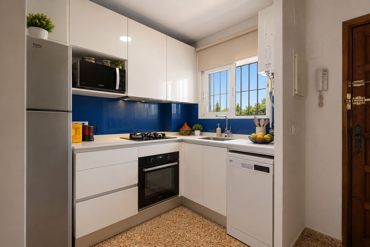 Cuisine moderne et fonctionnelle avec des armoires blanches brillantes, un plan de travail clair et une crédence bleue. Elle est équipée d'appareils intégrés et d'une fenêtre avec vue sur la verdure.