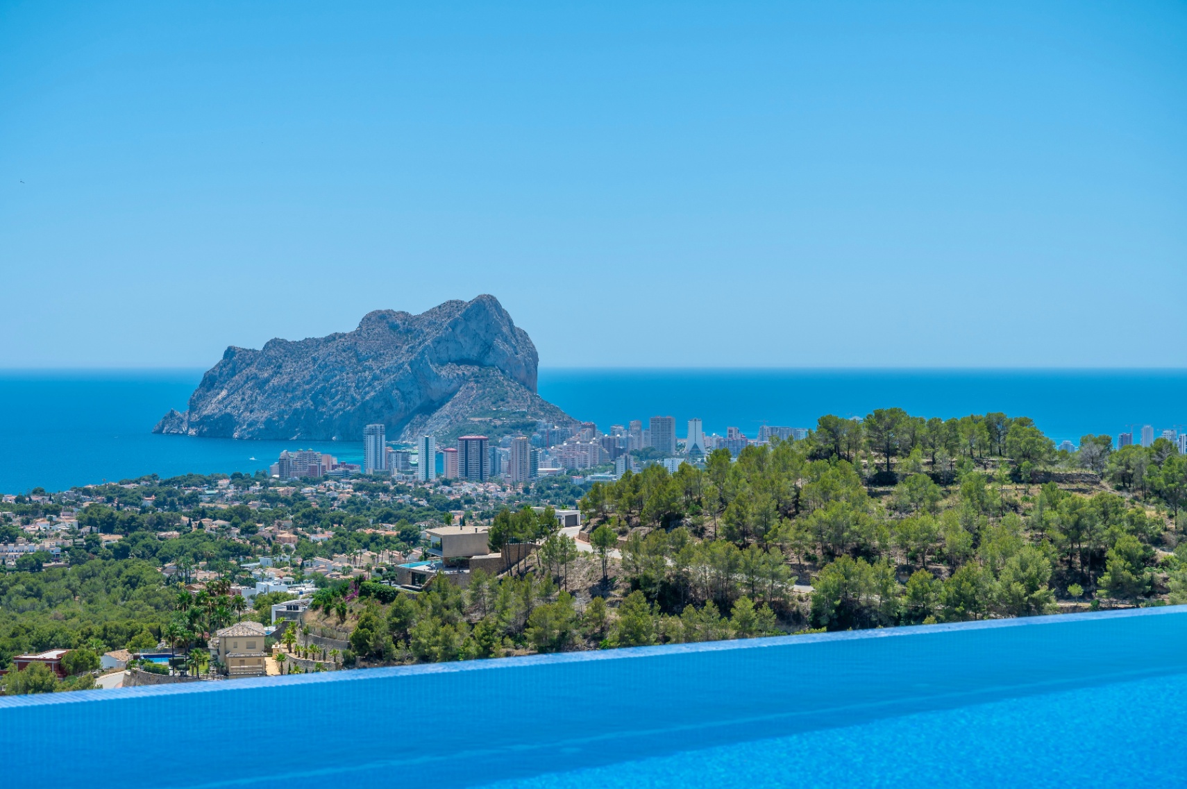 Bord de piscine à débordement offrant une vue panoramique sur la mer Méditerranée, Calpe et l'emblématique Peñon de Ifach. Bord de piscine à débordement offrant une vue panoramique sur la mer Méditerranée, Calpe et l'emblématique Peñon de Ifach.
