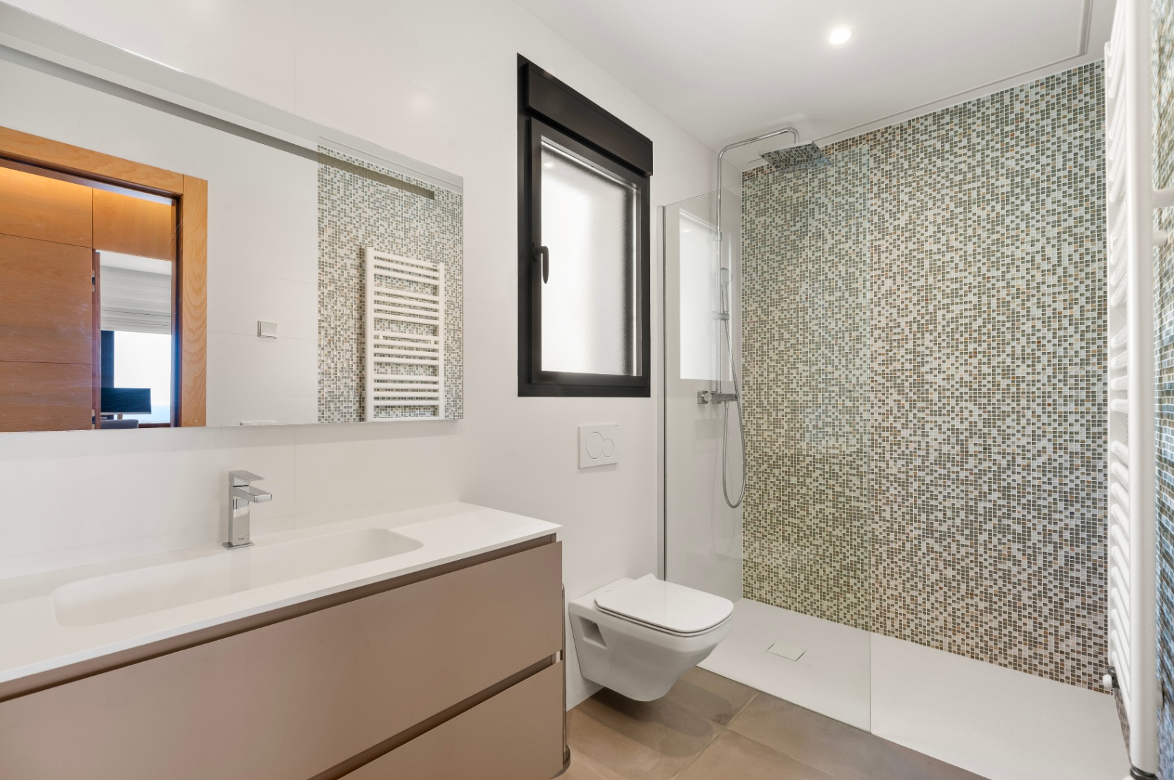 Salle de bain moderne avec douche à l'italienne et mur en mosaïque aux tons terreux. Elle dispose d'un meuble-lavabo suspendu avec vasque intégrée, toilettes murales et fenêtre à cadre noir. Salle de bain moderne avec douche à l'italienne et mur en mosaïque aux tons terreux. Elle dispose d'un meuble-lavabo suspendu avec vasque intégrée, toilettes murales et fenêtre à cadre noir.