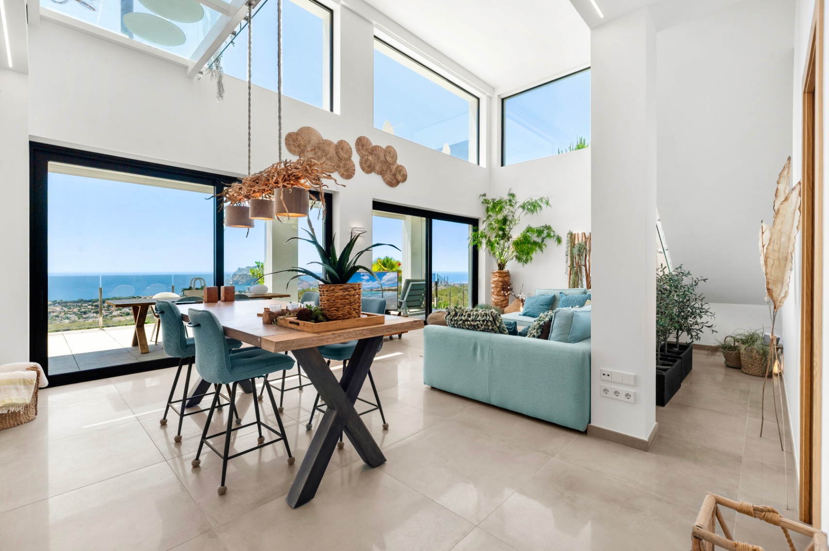 Vaste salon-salle à manger ouvert avec hauts plafonds, grandes fenêtres et un lustre unique en branches. Profitez de vues panoramiques sur la mer, la côte et le Peñón de Ifach depuis cet intérieur lumineux. Vaste salon-salle à manger ouvert avec hauts plafonds, grandes fenêtres et un lustre unique en branches. Profitez de vues panoramiques sur la mer, la côte et le Peñón de Ifach depuis cet intérieur lumineux.