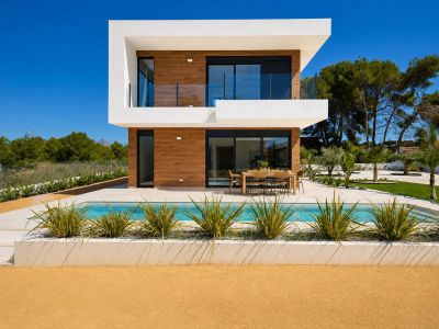 Extérieur de villa moderne avec piscine privée et salle à manger extérieure, façade à deux étages avec revêtement bois et grandes portes vitrées.