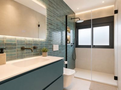 Salle de bain contemporaine avec mur d'accent en carreaux turquoise, robinetterie noire murale et douche à l'italienne avec fenêtre dépolie et niches éclairées.