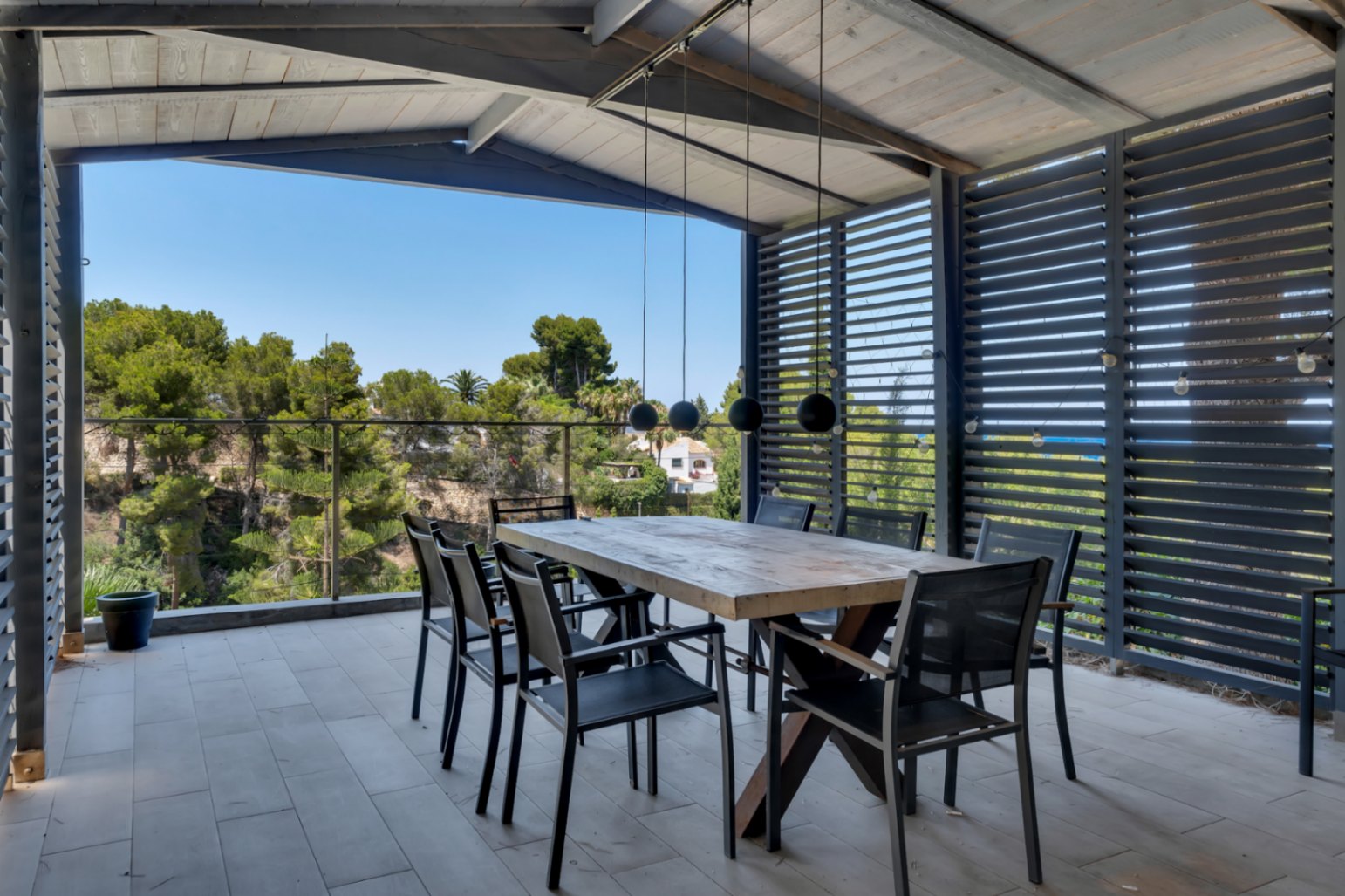 Vaste terrasse couverte avec carrelage clair, mobilier d'extérieur élégant et vues panoramiques. Espace idéal pour profiter du climat méditerranéen.