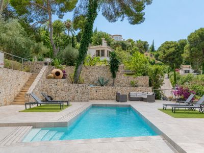 Piscine privée rectangulaire avec escaliers intégrés, bordée de dalles claires et de gazon synthétique avec transats. Murs en pierre naturelle et végétation méditerranéenne en terrasses.