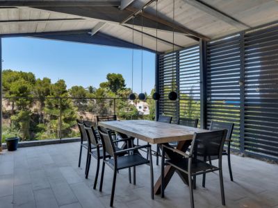 Vaste terrasse couverte avec carrelage clair, mobilier d'extérieur élégant et vues panoramiques. Espace idéal pour profiter du climat méditerranéen.