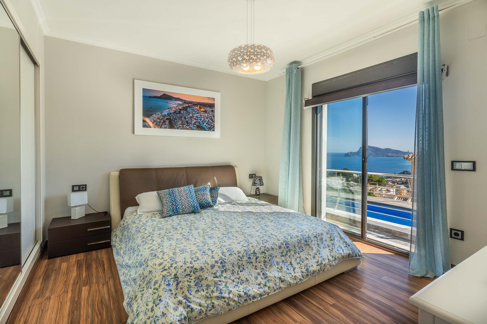 Chambre à coucher avec lit double, parquet stratifié et vue imprenable sur la mer depuis la grande baie vitrée. Armoire miroir intégrée.