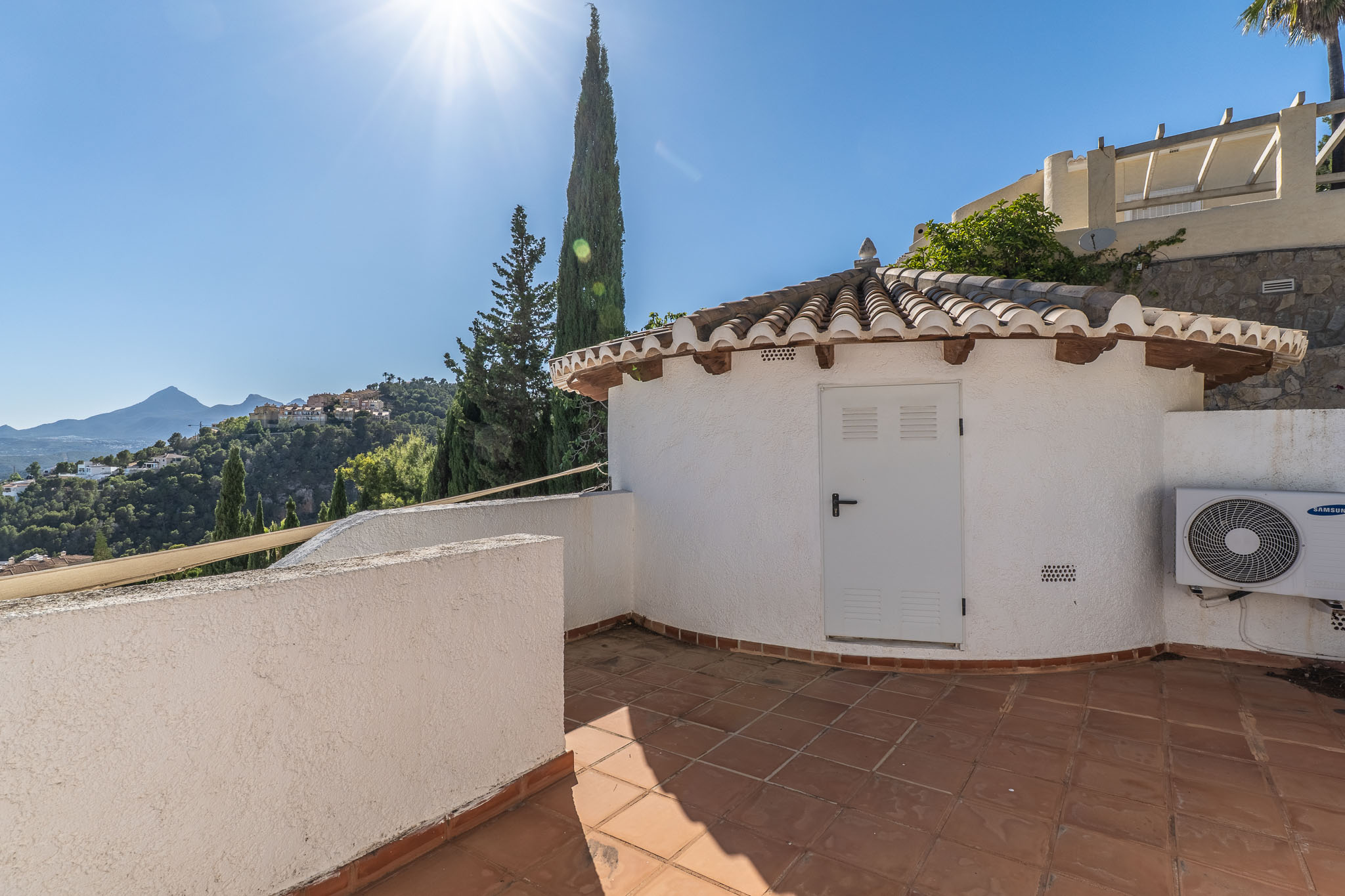 Terrasse carrelée de terre cuite avec un charmant bâtiment annexe au toit de tuiles traditionnelles. Offre des vues étendues sur les collines verdoyantes et les montagnes lointaines.