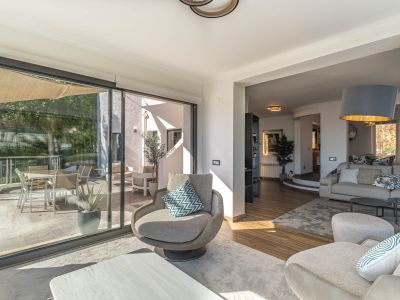 Salon moderne aux larges baies vitrées s'ouvrant sur la terrasse, offrant des vues panoramiques imprenables sur la Méditerranée et inondant l'espace de lumière naturelle.